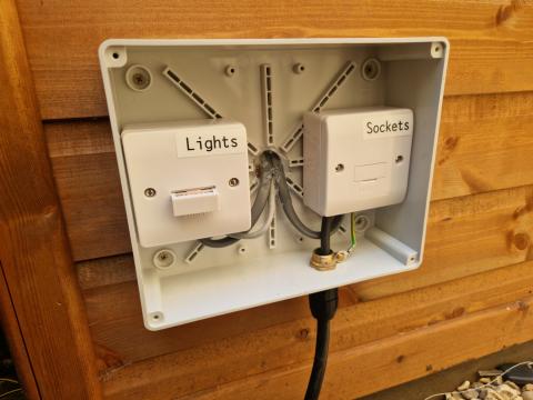 Weatherproof box with fused spurs for sockets and lights in a garden office